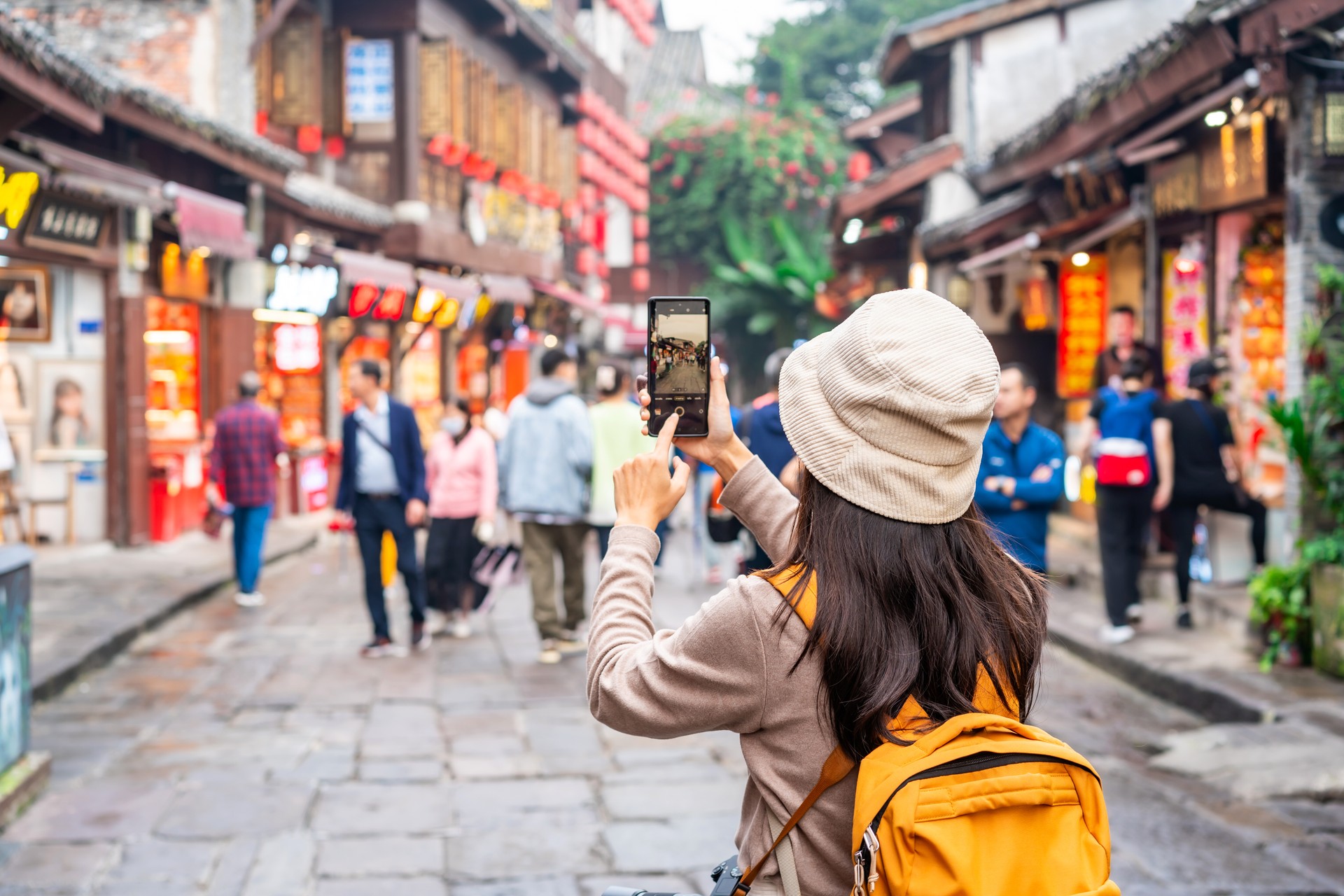 Young female tourist taking a photo of the Ciqikou ancient town in Chongqing, China